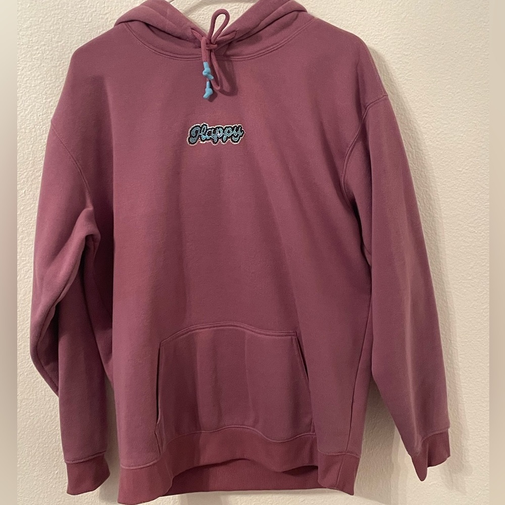 This is a purple hoodie with the word, happy bedazzled on the front